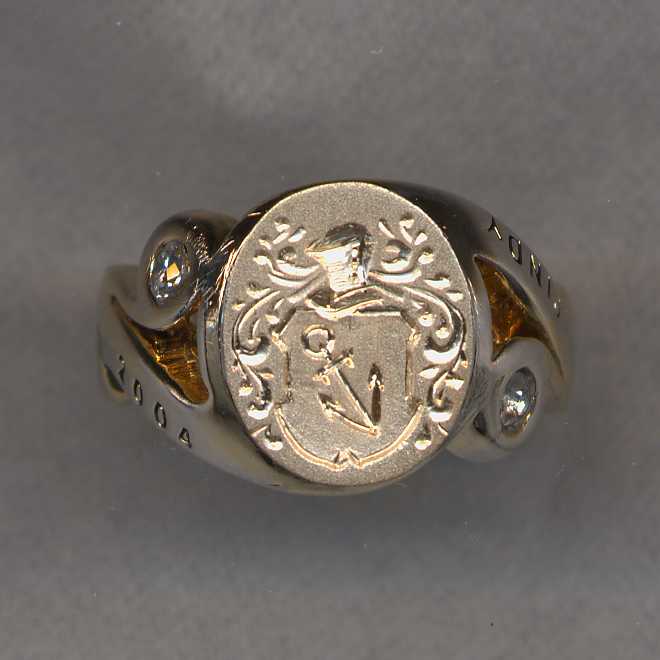This was an old ladies college ring. We have removed the stone and the upper level to create a larger engraving surface. We have added a gold plate on which we have engraved the family crest
